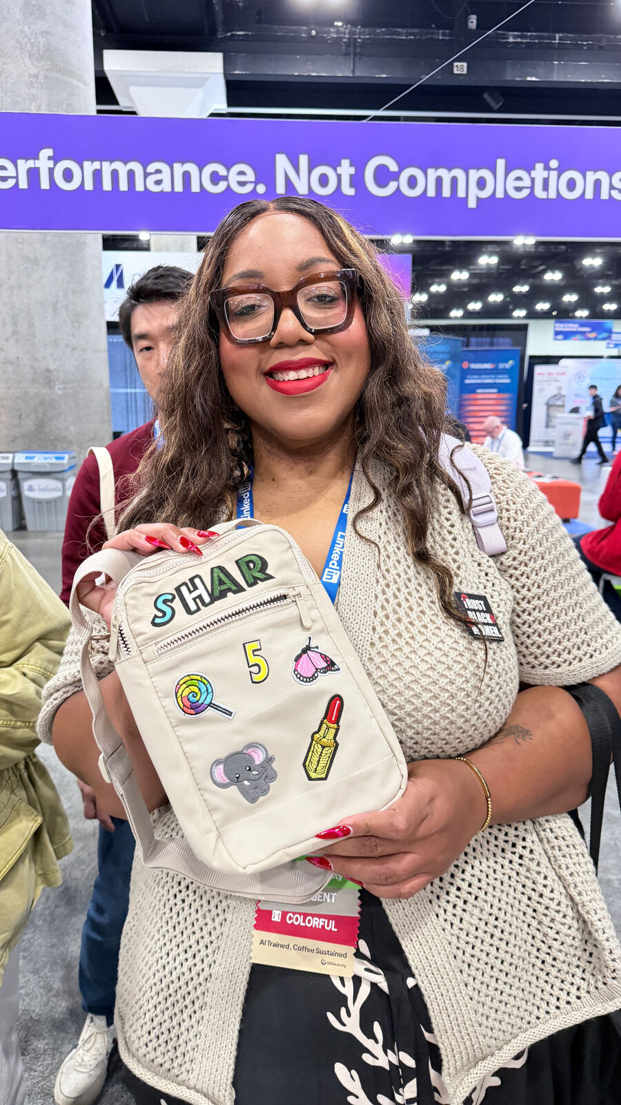 Close-up of branded tote bags with embroidered patches and decorative elements displayed at an event