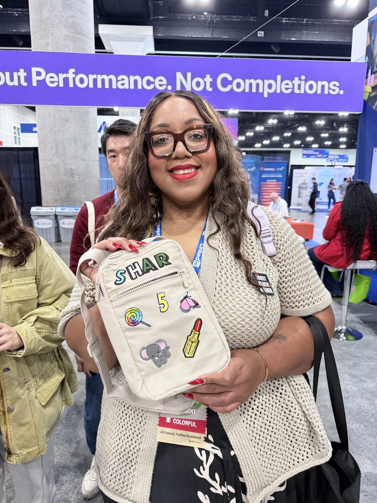 Smiling guest holding a personalized canvas bag they built at the station