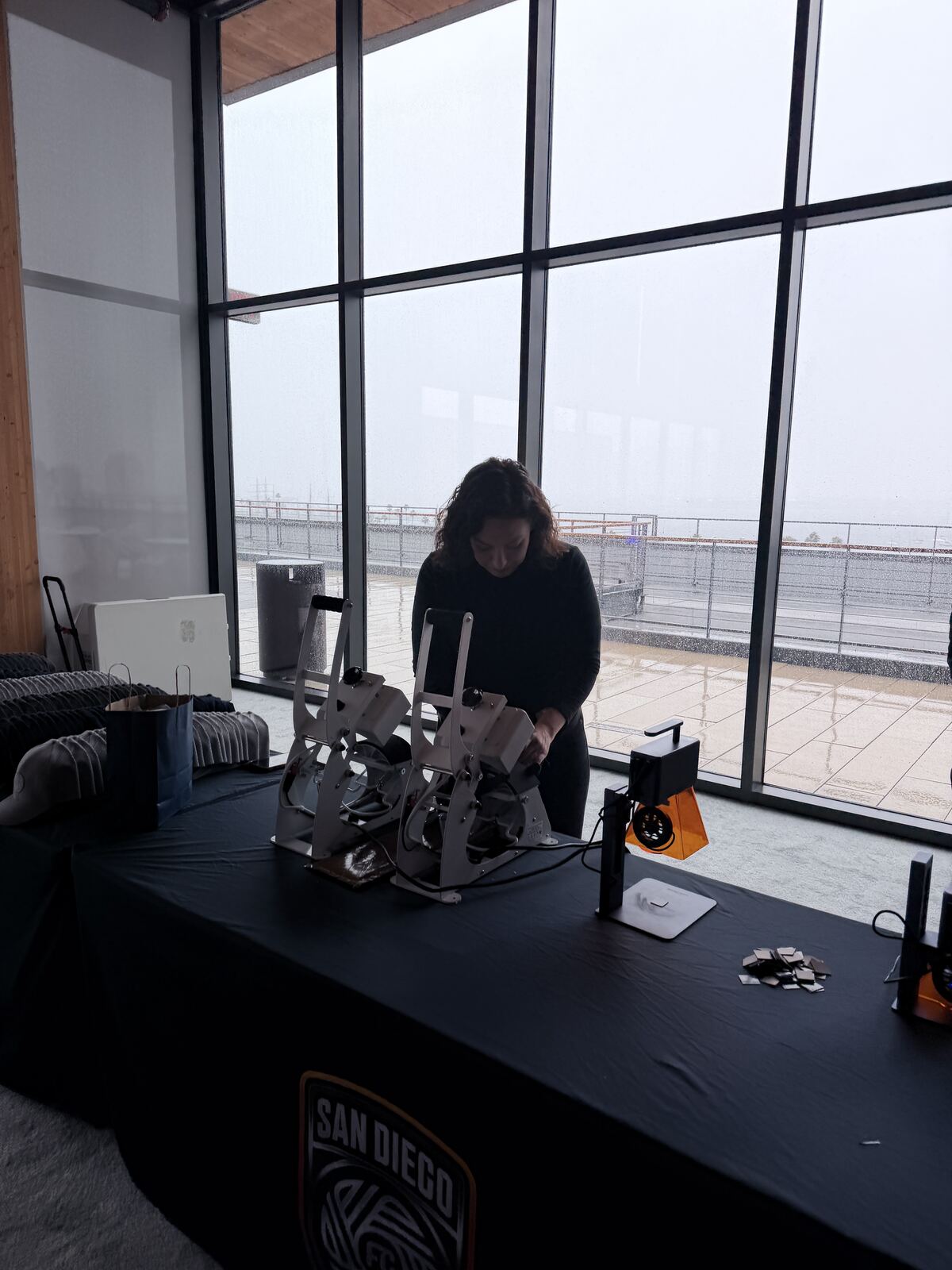 Staff member working at a booth with professional lighting setup visible through windows in background